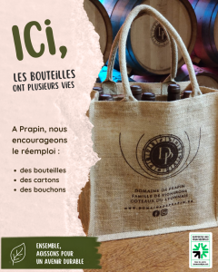 Visuel de communication du Domaine de Prapin sur le réemploi des bouteilles. On y voit un sac réutilisable en toile de jute rempli de bouteilles, placé devant des barriques, avec un message qui met en avant plusieurs vies pour les bouteilles, cartons et bouchons, dans une démarche durable.